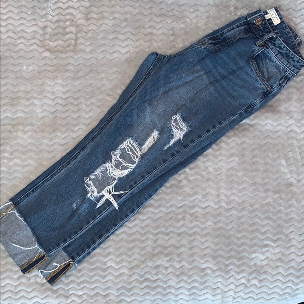 ripped medium wash jeans with cuffed legs